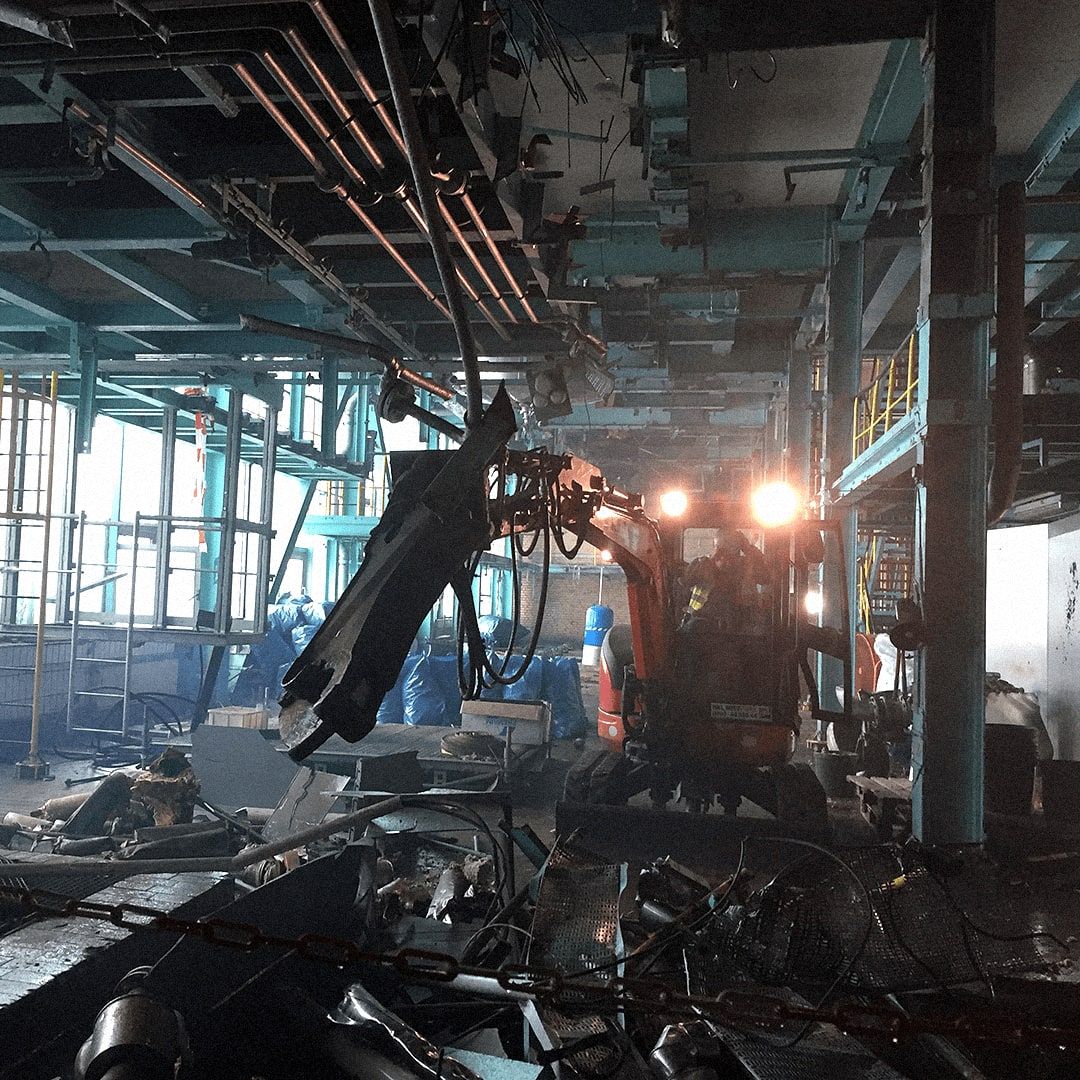 Longfront-Abbruchbagger beim Rückbau im Inneren einer Industriehalle